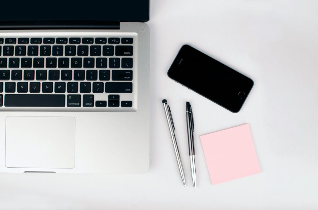 MacBook, iPhone og noter på skrivebord – visuel guide til Docman dokumenthåndtering i Joomla